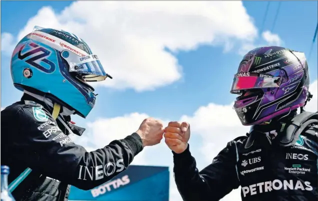  ??  ?? Bottas y Hamilton, compañeros en Mercedes, se saludan después de disputar la clasificac­ión del GP de Portugal.