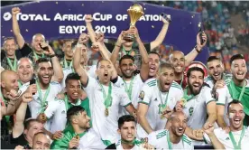  ?? Photograph: Suhaib Salem/Reuters ?? Riyad Mahrez lifts the trophy as Algeria celebrate winning the 2019 Africa Cup of Nations.