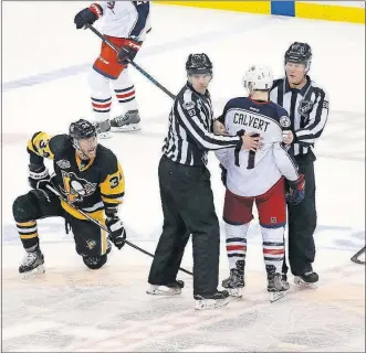  ?? [ADAM CAIRNS/DISPATCH] ?? Blue Jackets left wing Matt Calvert is restrained by officials after a hit on Penguins right wing Tom Kuhnhackl in the third period.