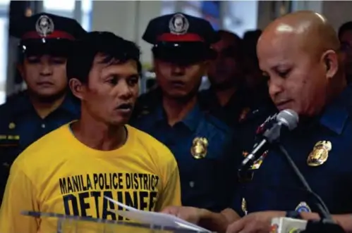  ?? (PHOTO COURTESY OF PNP-PIO) ?? MANILA. Philippine National Police chief Ronald dela Rosa (right) presents Abdul Nasser Lomondot (center), an alleged sub-group leader of the Maute terrorist group.