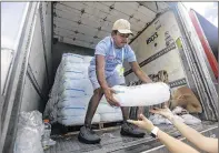  ?? PHOTOS BY BRUCE R. BENNETT / THE PALM BEACH POST ?? Volunteer Michael Fortes unloads bags of ice from a truck at PGA National during the first round of the Honda Classic on Thursday.