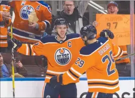  ?? The Canadian Press ?? Edmonton Oilers captain Connor McDavid celebrates one of his four goals with Leon Draisaitl during NHL action against the Tampa Bay Lightning on Monday in Edmonton.