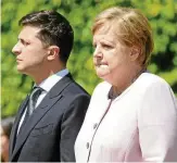  ??  ?? Merkel und Selenskyj lauschen den Hymnen.