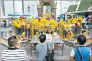  ?? NICOLAS AXELROD/GETTY IMAGES ?? People pay their respects Wednesday at the Erawan Shrine in Bangkok, Thailand. Authoritie­s in Thailand are searching for an “unidentifi­ed foreign man” who may have been responsibl­e for the bombing of the popular shrine Monday.