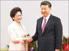  ??  ?? Lam (left) shakes hands with Xi after being sworn in as the territory’s new leader at the Hong Kong Convention and Exhibition Centre in Hong Kong. — AFP photo