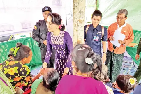  ?? — AFP photo ?? Suu Kyi (centre left) meets with Myo ethnic people in northern Maungdaw, Myanmar’s Rakhine State.