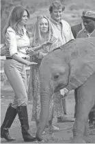  ?? SAUL LOEB/AFP/GETTY IMAGES ?? Aides help steady first lady Melania Trump after a baby elephant bumps into her at an elephant orphanage in Nairobi, Kenya, on Oct. 5.