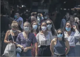  ?? EMILIO MORENATTI — THE ASSOCIATED PRESS ?? Tourists wearing face masks wait to cross a road in downtown Barcelona, Spain, Thursday.