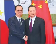  ?? WANG JING / CHINA DAILY ?? State Counselor and Foreign Minister Wang Yi (right) shakes hands with Philippine Foreign Affairs Secretary Alan Peter Cayetano before their meeting at the Diaoyutai State Guesthouse in Beijing on Wednesday.