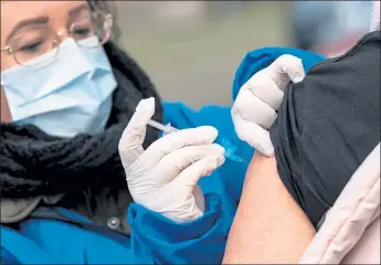  ?? Johan Nilsson / AFP via Getty Images ?? A nurse in Sweden administer­s a flu vaccine on Thursday. Investors are cheering the rapid developmen­t of potential COVID-19 vaccines.