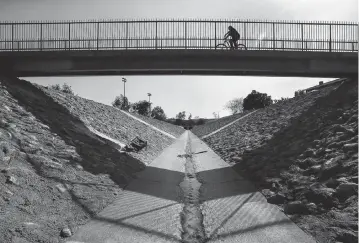  ?? MEL MELCON Los Angeles Times/TNS ?? A bicycle rider pedals across a bridge in Pacoima in Los Angeles, Calif., which explored revitalizi­ng public space as one way to tackle high rates of health problems.