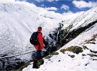  ??  ?? LEFT Loch Skeen is home to bountiful wildlife, including the vendace, Britain’s rarest freshwater fish ABOVE A walker takes in the fascinatin­g frozen landscape of Grey’s Mare Tail waterfall in winter