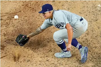  ?? AP Photo/David J. Phillip ?? ■ Los Angeles Dodgers starting pitcher Julio Urias can't get a glove on a base hit by Atlanta Braves' Charlie Culberson during the fifth inning in Game 3 of a baseball National League Championsh­ip Series on Wednesday in Arlington, Texas.