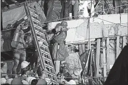  ?? [ANTHONY VAZQUEZ/THE ASSOCIATED PRESS] ?? A ladder is raised for search and rescue team members at the Enrique Rebsamen school in Mexico City, where at least one child reportedly was buried alive. But that hope fell apart Thursday, and it was unclear how the riveting storyline had emerged.