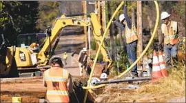  ?? Rich Pedroncell­i Associated Press ?? PACIFIC Gas & Electric workers bury power lines in Paradise, Calif. The utility wants to pay its $4-million fine for starting the Camp fire out of a victims fund.