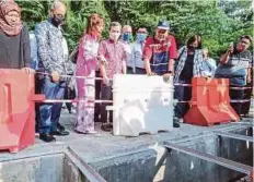  ?? ?? DR Shahidan (tiga dari kanan) bersama Teresa (tiga dari kiri) dan Ahmad Fahmi (empat dari kiri) meninjau kawasan hotspot banjir kilat di Bukit Nenas. - Gambar NSTP/FARIZ ISWADI ISMAIL