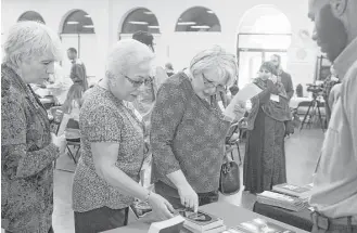  ?? Marie D. De Jesús / Houston Chronicle ?? Dolores Morales, from left, Maria Tamez and Narsedalia Lopez select reading materials to learn more about Islam during Open Mosque Day at the Bear Creek Islamic Center.