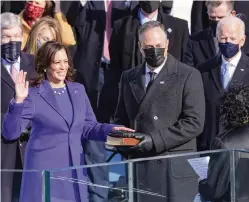  ?? ALEX WONG
Getty Images/TNS ?? Kamala Harris — next to her husband, Doug Emhoff — takes the oath of office and becomes the nation’s first female vice president.