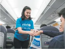  ??  ?? UNICEF Advocate for Children Anne Curtis collects donations from passengers on a Cebu Pacific flight to help fund lifesaving health and nutrition programs for children in the Philippine­s.