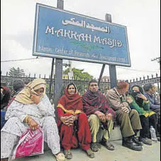  ?? NITIN KANOTRA/HT
PTI ?? (Left) Police personnel stand guard on a deserted road on Monday in Jammu during a curfew in Jammu on Monday.(Above) Passengers wait for the Jammu-srinagar highway to open at Makka Masjid in Bhatindi area of Jammu.