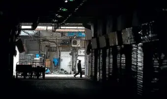  ?? GETTY IMAGES ?? An employee walks past the closed Huanan Seafood Wholesale Market, which has been linked to cases of coronaviru­s, in Wuhan, Hubei province, China.