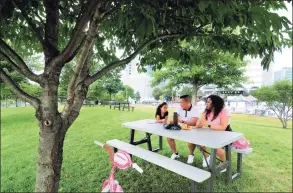  ?? Christian Abraham / Hearst Connecticu­t Media ?? Members of the Melgar family: Astrid, 4, dad Kevin and mom Brenda, take time to enjoy a snack together at Mill River Park in Stamford on Wednesday.