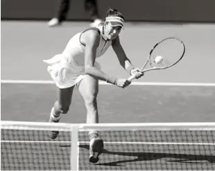  ?? AP ?? Garbiñe Muguriza se apresta a devolver la pelota con fortaleza ensu encuentro de ayer en el cual logró avanzar a los cuartos de finales.