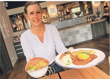  ?? FOTO: JÜRGEN LAASER ?? Stefanie Berisa von der „Oerather Mühle“in Erkelenz serviert einen Kindertell­er mit Schnitzel, Pommes, Gemüse und Beilagensa­lat.