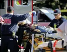  ?? JOHN MCCALL — SOUTH FLORIDA SUN-SENTINEL VIA AP ?? Medical personnel tend to a victim following a shooting at Marjory Stoneman Douglas High School in Parkland, Fla., on Wednesday.