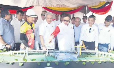  ?? ?? PENGHUBUNG RAKYAT: Abang Johari melihat replika Jambatan Lawas semasa lawatan ke tapak projek di Lawas, semalam. Turut kelihatan, Awang Tengah (tiga kiri).