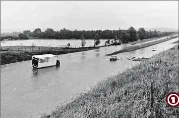  ??  ?? The storms of 1973 saw the one-time A20 Ashford bypass under water. Here drivers including one in a Sainsbury’s lorry - have become stranded in the floods