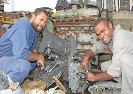  ?? Photo: Ronald Kumar. ?? From left: Former national sevens team winger Isikeli Vuruna and former Flying Fijians halfback Aporosa Kenatale work on an outboard engine at Stanley Brown Naval Base in Walu Bay, Suva, on May 19, 2020.