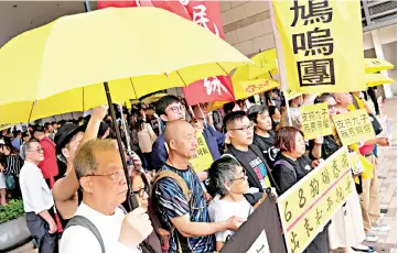  ??  ?? Pro-democracy supporters hold yellow umbrella to support leaders of Occupy Central activists, outside the court, in Hong Kong, China.
