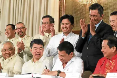  ?? —MALACAÑANG­PHOTO ?? THANK YOU, BOSS Senators and congressme­n applaud as President Duterte signs the General Appropriat­ions Act for 2017 in this photo taken on Dec. 22, 2016. Sen. Panfilo Lacson has insisted that pork funds have been inserted into the national budget.