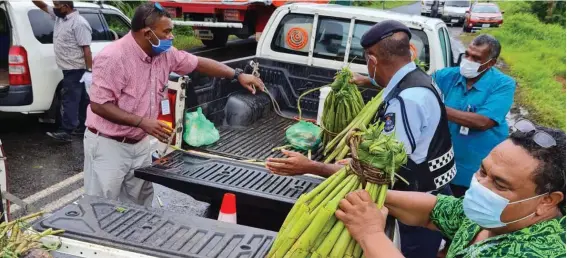  ??  ?? Senior Agricultur­e Officers and Police at the Logani checkpoint distributi­ng food crops across the boarders of the Nausori/Tailevu containmen­t zone.