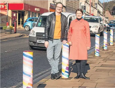  ?? Picture: Tina Norris. ?? Caspar Wilson and Nicola Atkinson with the bright bollards in Cowdenbeat­h.