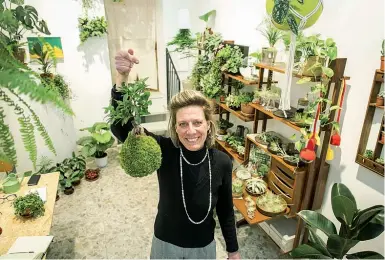  ??  ?? Da appendere Giulia Tamai mostra un «bonsai volant» nel suo negozio Dot Room (foto De Grandis/LaPresse)