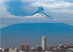  ??  ?? Otra vez en actividad. Vista general del volcán Popocatépe­tl desde la ciudad de Puebla durante una erupción.