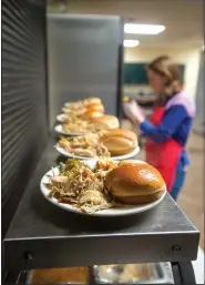  ?? NWA Democrat-Gazette/BEN GOFF • @NWABENGOFF ?? Shelbi Fowler of Bentonvill­e volunteers to help in the kitchen Tuesday while serving the evening meal at the Salvation Army Emergency Shelter in Bentonvill­e.