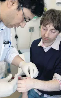  ?? PHOTO: PAUL HUGHES ?? Trackable . . . A surgeon implants an RFID microchip into a man’s hand.