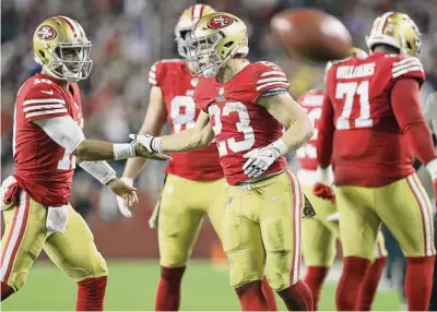  ?? Scott Strazzante /The Chronicle ?? Christian McCaffrey and Jimmy Garoppolo (left) slap hands during the 49ers’ 22-16 win over the Chargers on Sunday night. San Francisco coach Kyle Shanahan’s magic number of 40-plus rushes for the game: 41 carries between McCaffrey and newly returned Elijah Mitchell.