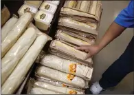  ?? (Bloomberg News WPNS/Luke Sharrett) ?? An employee restocks loaves of french bread at a supermarke­t in Louisville, Ky.