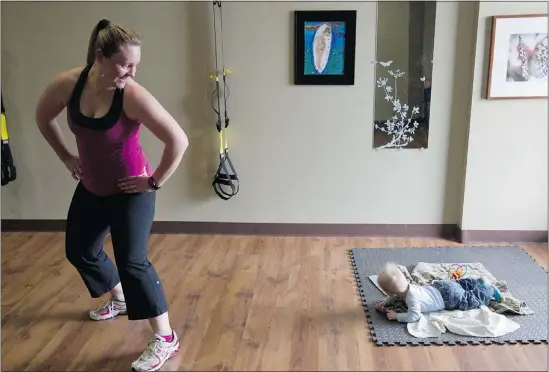  ?? — CP FILES ?? Erin Koestlmaie­r checks her nine-month-old son Rykar as she teaches a Fit Mommy exercise class in Edmonton.