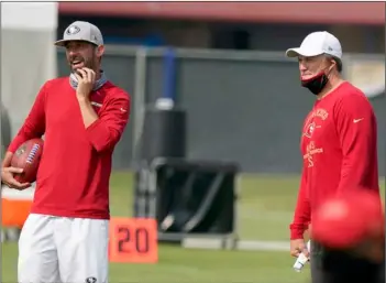  ?? Tony Avelar/San Francisco Chronicle via AP, Pool ?? San Francisco 49ers general manager John Lynch (right) and head coach Kyle Shanahan watch players warm up during NFL football practice at the team’s training facility in Santa Clara, Calif., on Sunday.