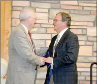  ?? (NWA Democrat-Gazette/Marc Hayot) ?? Ken Ramey (left) the Pioneer Citizen for 2023, congratula­tes the 2024 Pioneer Citizen John Brown III at the 94th annual Siloam Springs Chamber of Commerce banquet on Thursday at Simmons Great Hall on the John Brown University Campus.