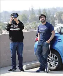  ?? ALEX HORVATH / THE CALIFORNIA­N ?? Saul Gonzalez, left, and his friend Samuel Ramirez were visiting from Salinas when they heard that a variety of military aircraft would make appearance­s over Bakersfiel­d on Friday. The friends went to the top of Bakersfiel­d’s downtown parking garage, where a group of curious residents, aviation buffs and photograph­ers were gathered to watch the flyover organized by the Aerospace Valley Hybrid Airshow.