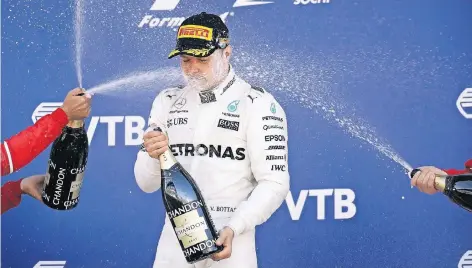  ?? FOTO: DPA ?? Valtteri Bottas wird in Sotschi nach seinem Premierens­ieg in der Formel 1 von Sebastian Vettel und Kimi Räikkönen nass gemacht.