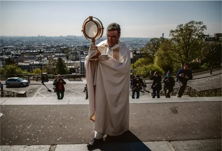  ?? Photo Christophe Petit Tesson. MAXPPP ?? L’archevêque de Paris, Mgr Michel Aupetit, mène une bénédictio­n devant la basilique du Sacré-Coeur, le 9 avril à Paris.