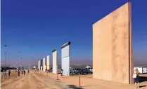  ?? ELLIOTT SPAGAT/ASSOCIATED PRESS ?? People look at prototypes of border walls in San Diego in October 2017. President Donald Trump will visit the prototypes today, before attending a fundraiser.