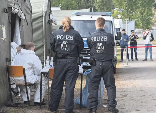  ?? ?? Willkommen in Deutschlan­d: Polizist*innen warten auf Geflüchtet­e in der Zentralen Erstaufnah­meeinricht­ung des Landes Brandenbur­g.